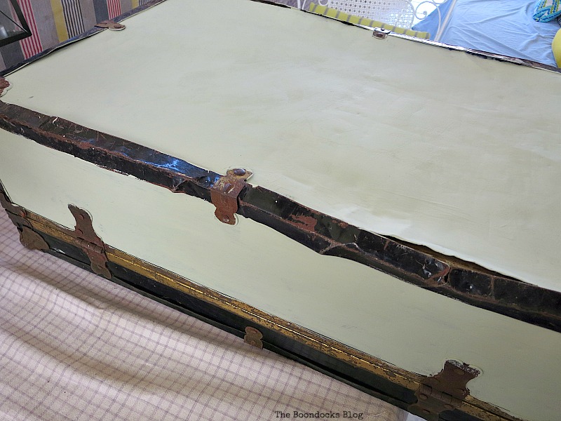 Painting the sides top and bottom of a vintage suitcase white.