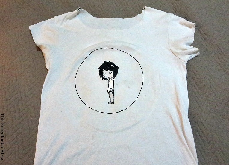 Old white tshirt with a circle and an image of a girl character in the middle.