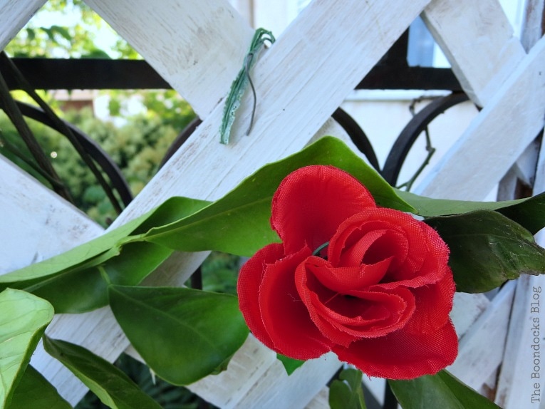 Placing the plastic stems as hooks on the lattice flower wall.