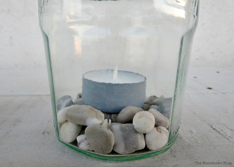 pebbles and tea lights inside jar, How to make Simple Lanterns with Repurposed Jars, www.theboondocksblog.com