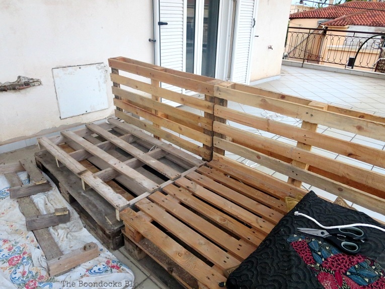 front view of pallets, Quickly Make a Super Easy Pallet Couch www.theboondocksblog.com