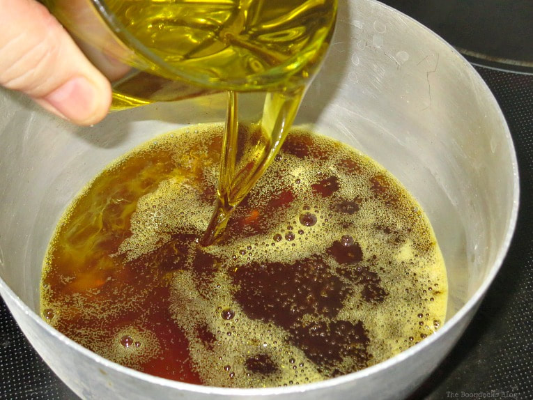 Adding olive oil to the melted beeswax.