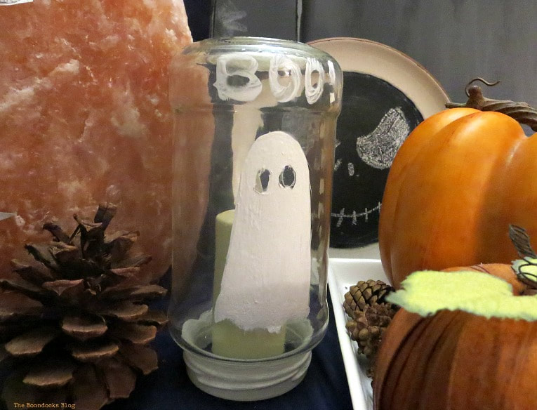 A glass jar painted with a ghost, How to Make an Easy and Thrifty Halloween Vignette www.theboondocksblog.com