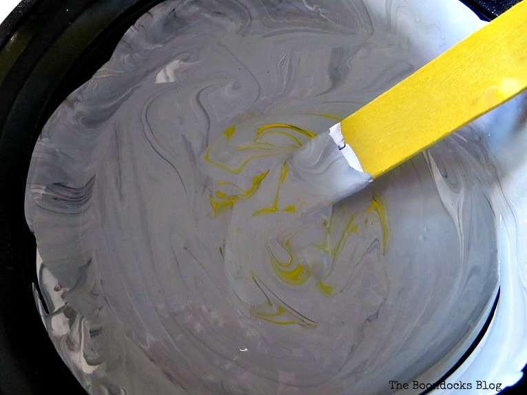 Adding yellow paint to the gray mixture.