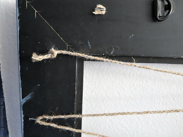 Back of picture frame with twine knotted onto staple, How to Make an Easy Frame Jewelry Organizer www.theboondocksblog.com
