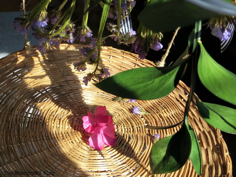 Close up of a wicker plate charger and flowers.