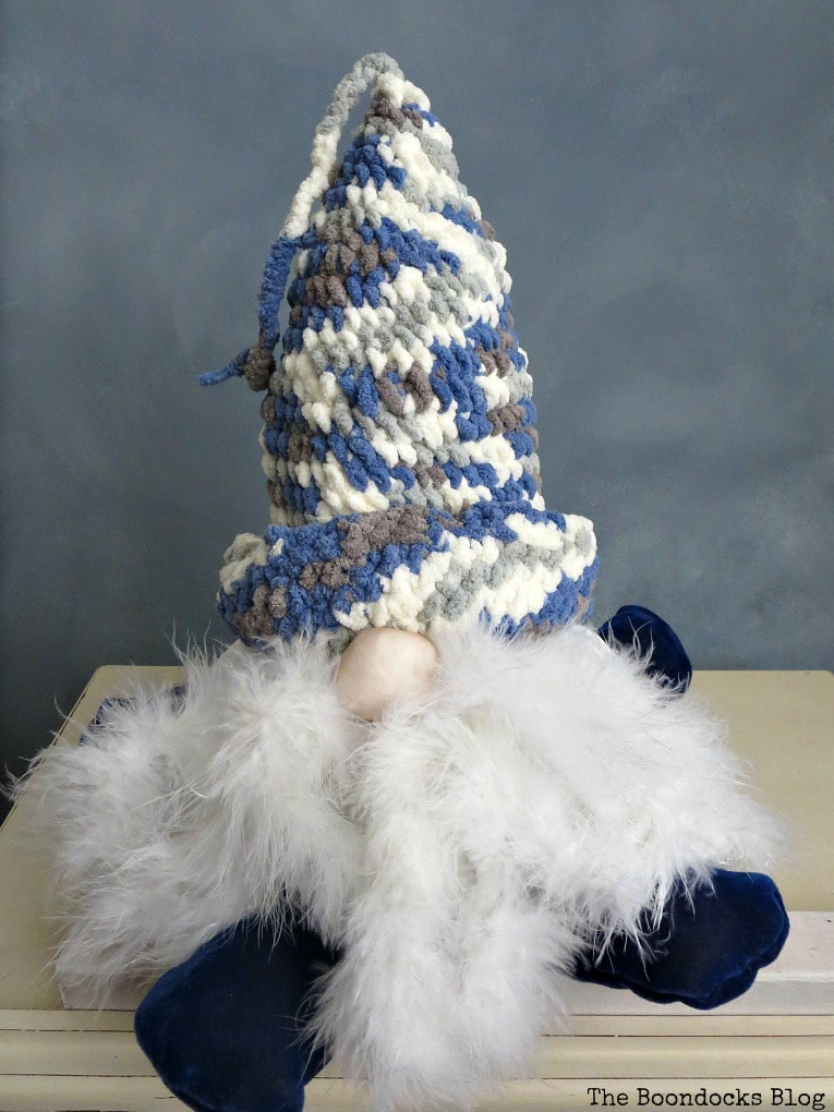 Gnome with crocheted beanie in blue, grey and white colors, #gnomemaking #sewingproject #easycraftidea #crochetedhat #DIYproject #gnomemadefromtshirt How to Fail Miserably at Gnome Making www.theboondocksblog.com