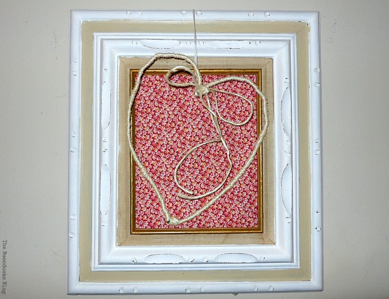 Frame decorated with a wire heart and repurposed old clothes.