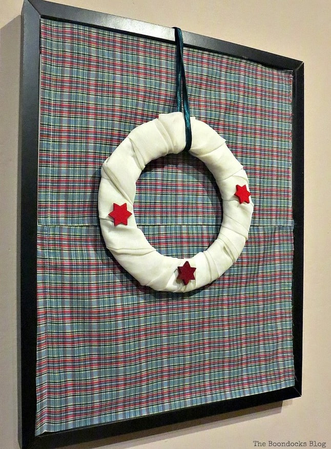 Christmas wreath hanging from a picture frame.