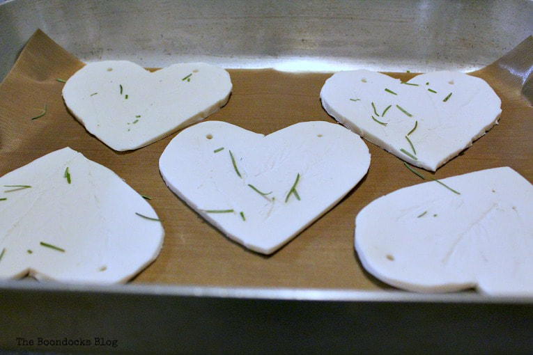 Putting the clay in the oven to bake, How to Make a Natural Clay Valentine's Heart Garland www.theboondocksblog.com