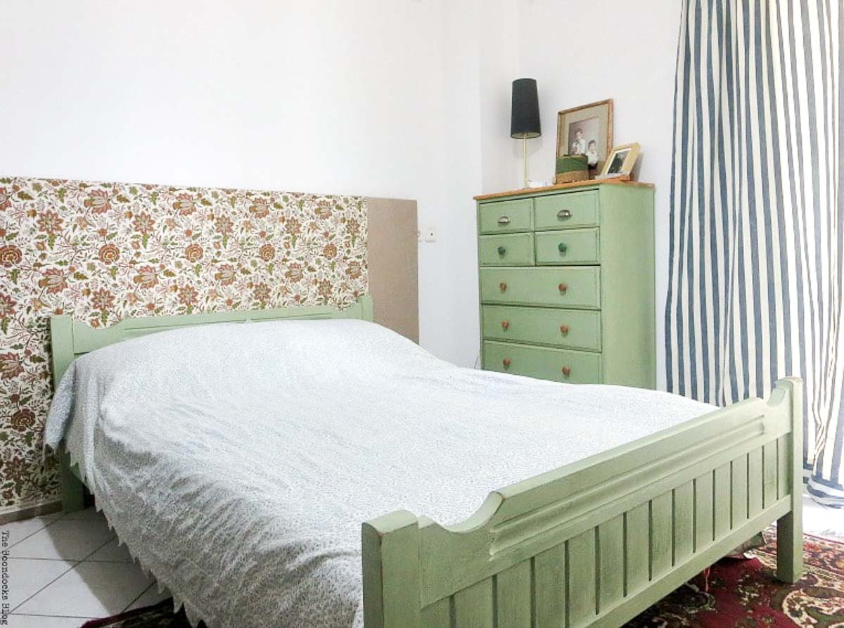 Green painted dresser and bed frame. The bed has a flower fabric head board.